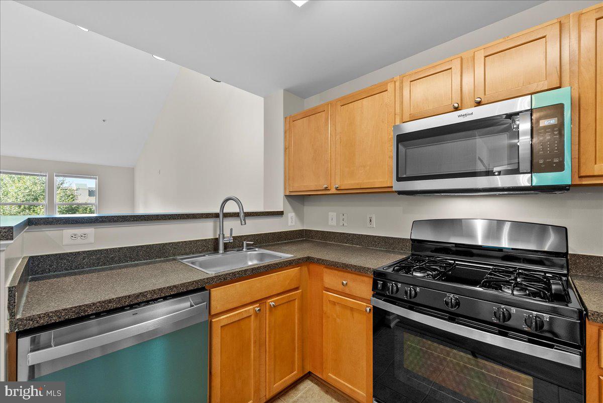 12000 Market Street, Unit 469 Reston, VA 20190 - Photo 9 of 41 a kitchen with granite countertop a sink cabinets and stainless steel appliances