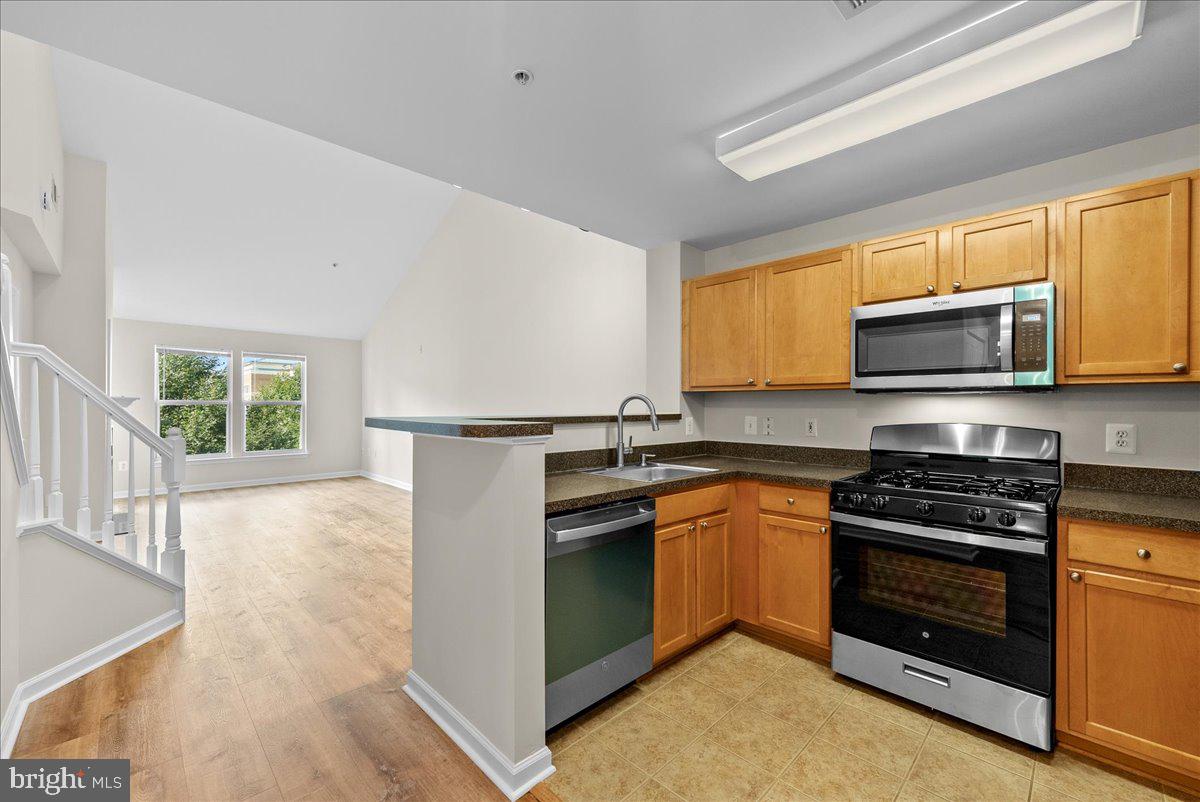 12000 Market Street, Unit 469 Reston, VA 20190 - Photo 10 of 41 a kitchen with stainless steel appliances granite countertop a stove microwave and sink
