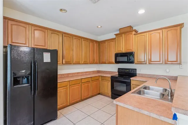 a kitchen with stainless steel appliances granite countertop a refrigerator oven a sink dishwasher and wooden cabinets
