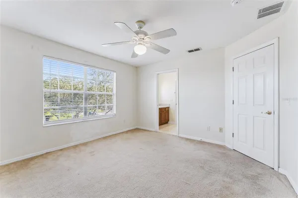 an empty room with a ceiling fan and a window