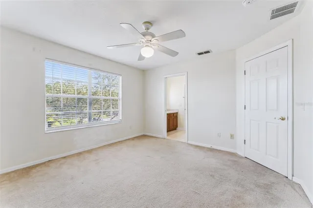 an empty room with a ceiling fan and a window