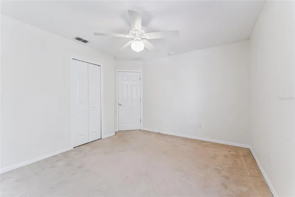an empty room with a chandelier fan