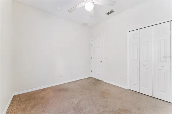 an empty room with a window and a fan