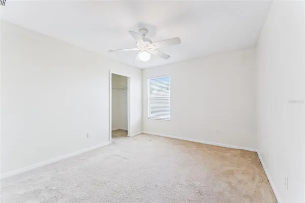 an empty room with a window and a fan