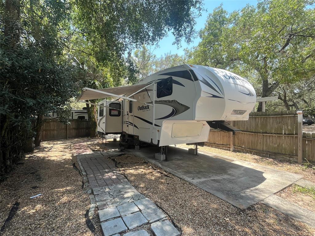 3000 Clarcona Road, Unit 554 Apopka, FL 32703 - Photo 1 of 8 a view of a white house with a large tree and wooden fence