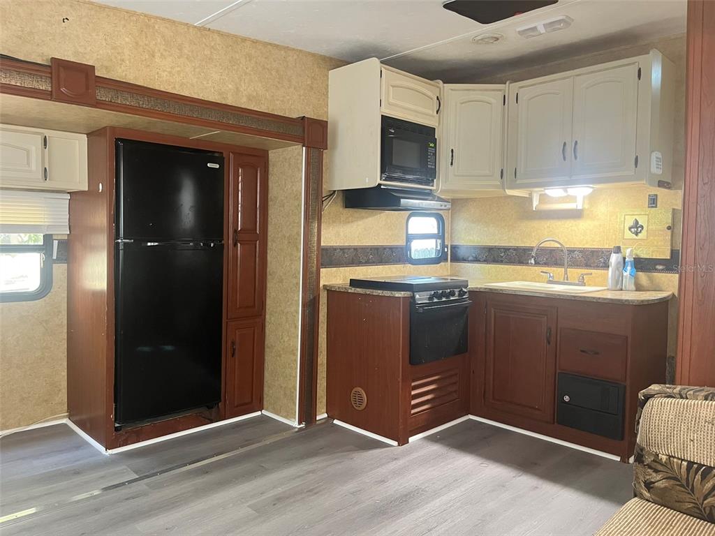 3000 Clarcona Road, Unit 554 Apopka, FL 32703 - Photo 2 of 8 a kitchen with stainless steel appliances granite countertop a refrigerator and a stove