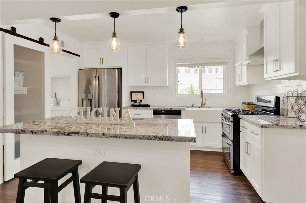 a kitchen with kitchen island granite countertop a stove a sink and a refrigerator