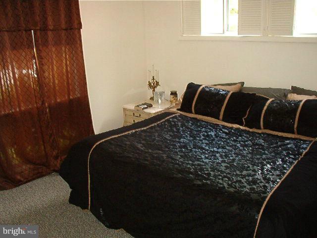 7516 Knollwood Road Baltimore, MD 21286 - Photo 3 of 7 a bed sitting in a bedroom next to a window