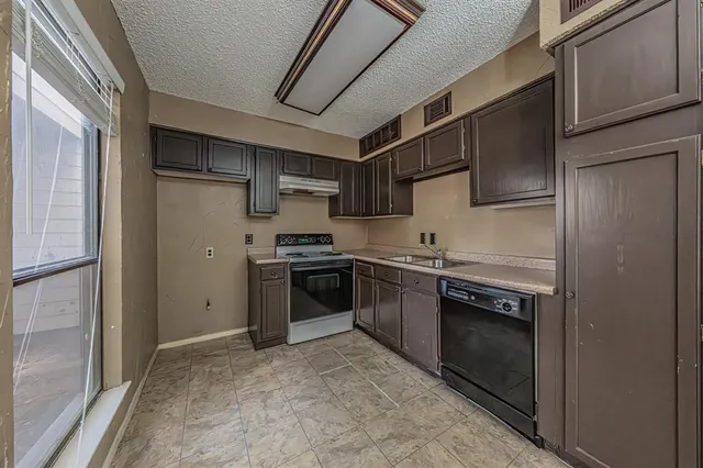 a kitchen with stainless steel appliances granite countertop a refrigerator and a stove