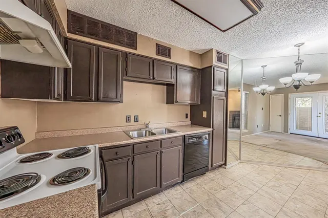 a kitchen with a sink a stove and cabinets