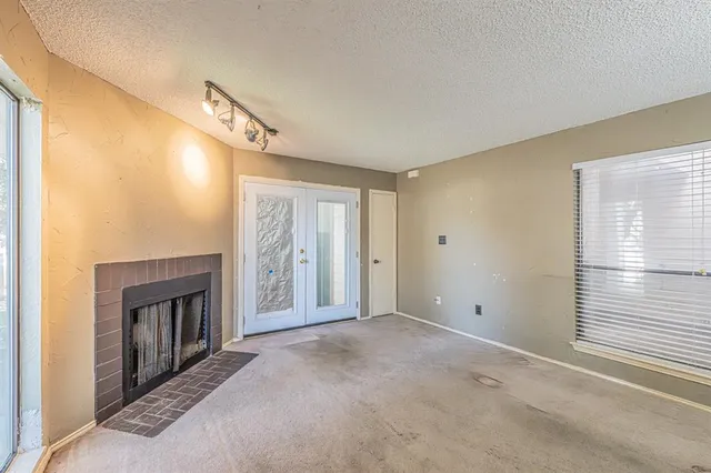 a view of an empty room with a fireplace and a window
