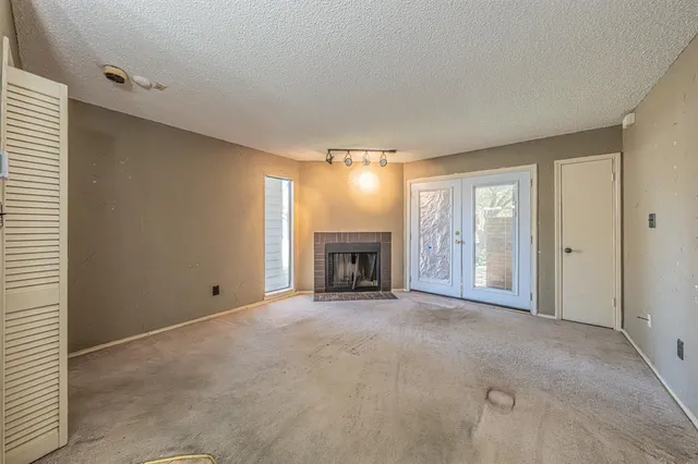 a view of an empty room with a fireplace and a window