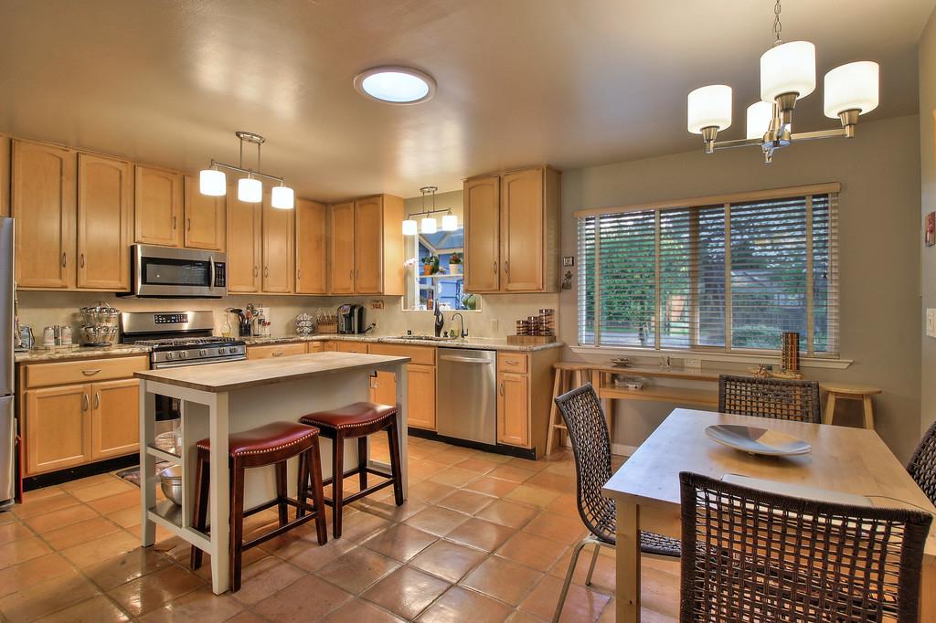 180 Locust Lane Ben Lomond, CA 95005 - Photo 12 of 33 a kitchen with a table chairs microwave and cabinets