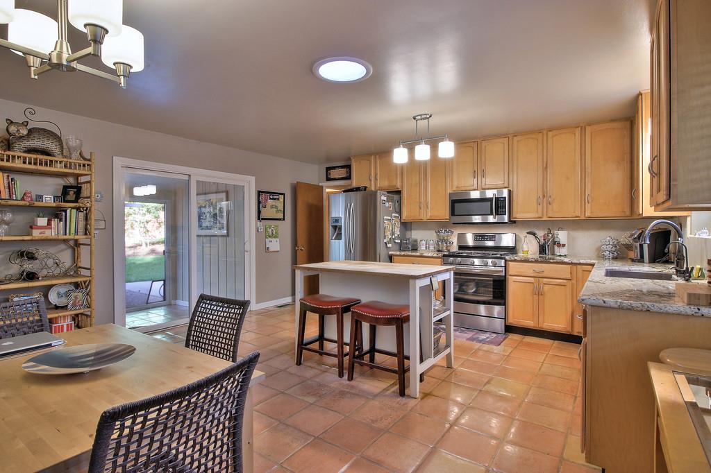 180 Locust Lane Ben Lomond, CA 95005 - Photo 4 of 33 a kitchen with kitchen island granite countertop a stove a sink a dining table and chairs