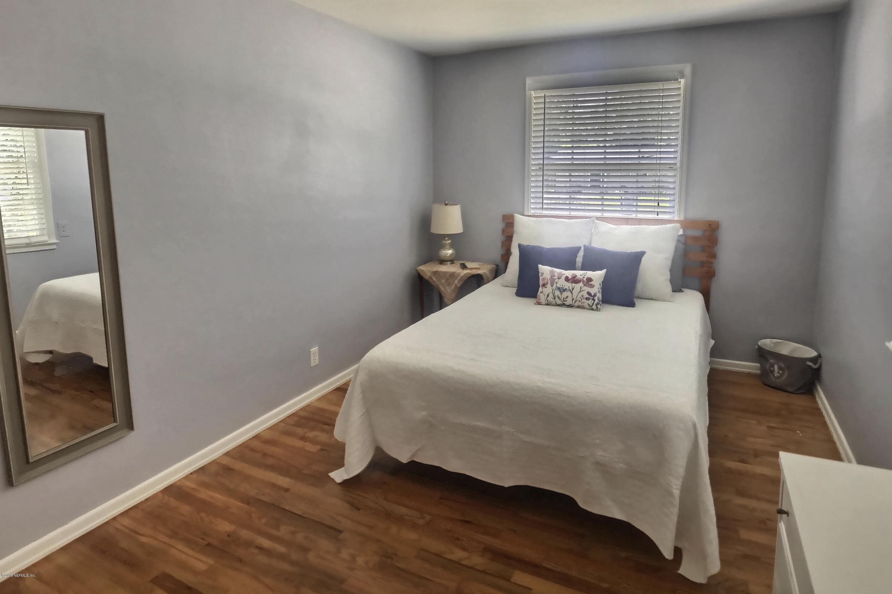 4631 Martingale Road Jacksonville, FL 32210 - Photo 18 of 27 a bedroom with a bed and wooden floor
