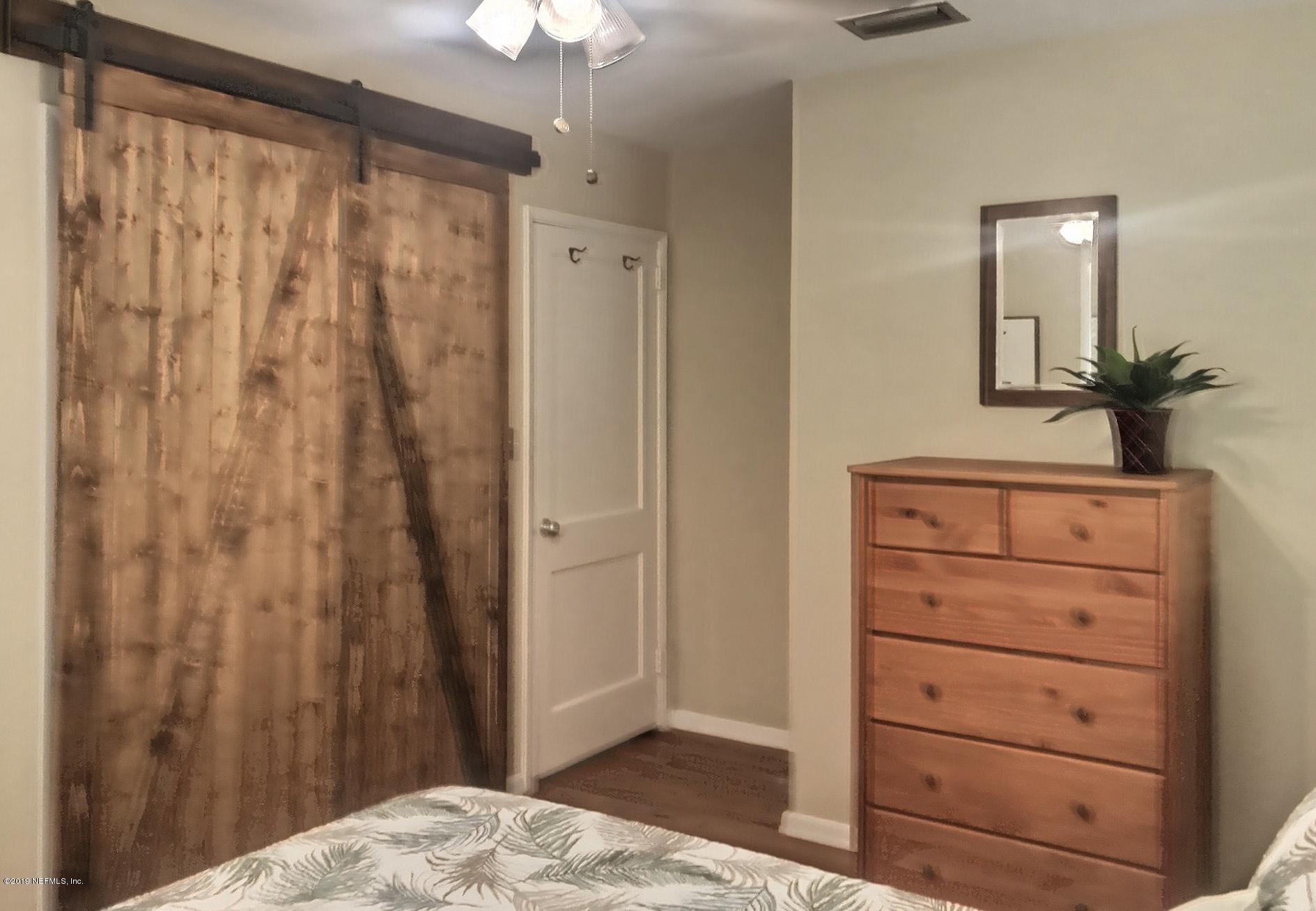 4631 Martingale Road Jacksonville, FL 32210 - Photo 23 of 27 a bedroom with a bed and a dresser