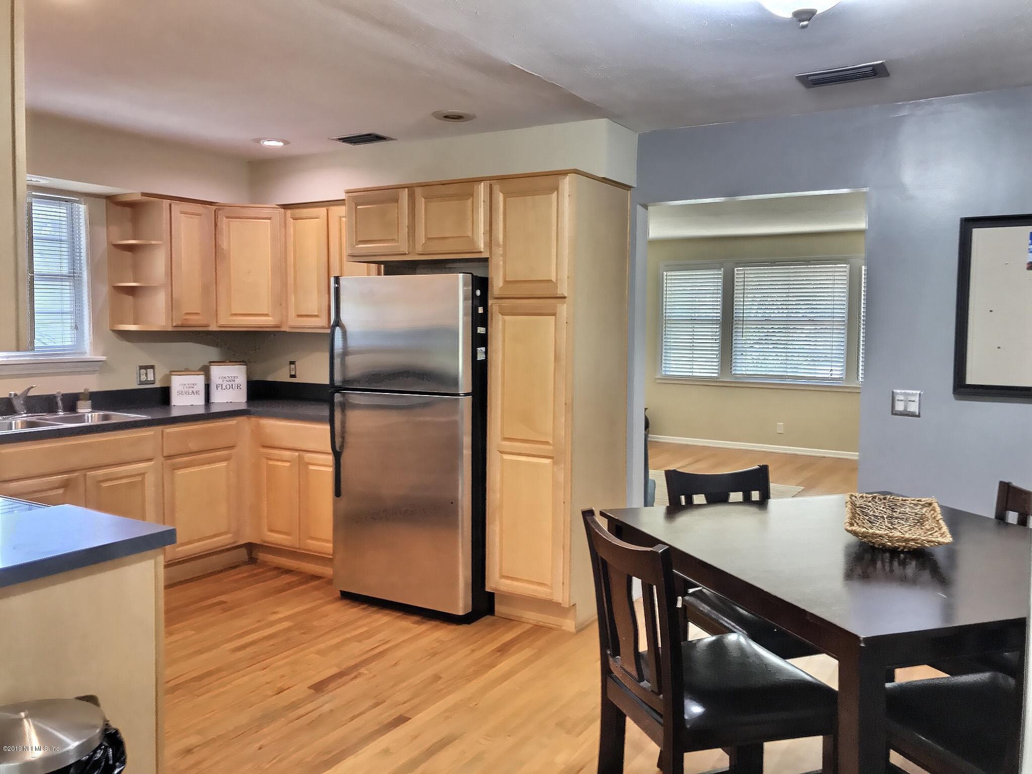 4631 Martingale Road Jacksonville, FL 32210 - Photo 3 of 27 a kitchen with stainless steel appliances granite countertop a refrigerator a sink a stove a dining table and chairs