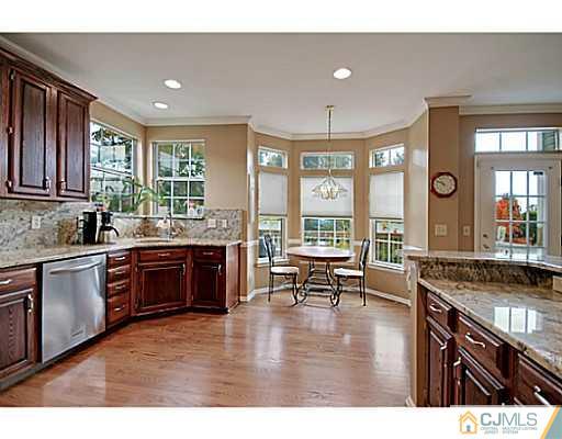 191 Smoke Rise Road Bernards, NJ 07920 - Photo 2 of 25 a open kitchen with granite countertop a stove top oven a sink dishwasher a dining table and chairs with wooden floor