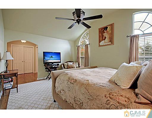 191 Smoke Rise Road Bernards, NJ 07920 - Photo 19 of 25 a bedroom with a bed and a chandelier