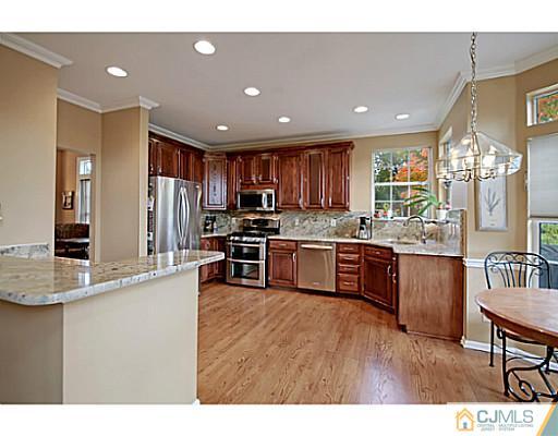 191 Smoke Rise Road Bernards, NJ 07920 - Photo 3 of 25 a kitchen with stainless steel appliances kitchen island granite countertop a refrigerator a sink dishwasher a stove with wooden cabinets and floor