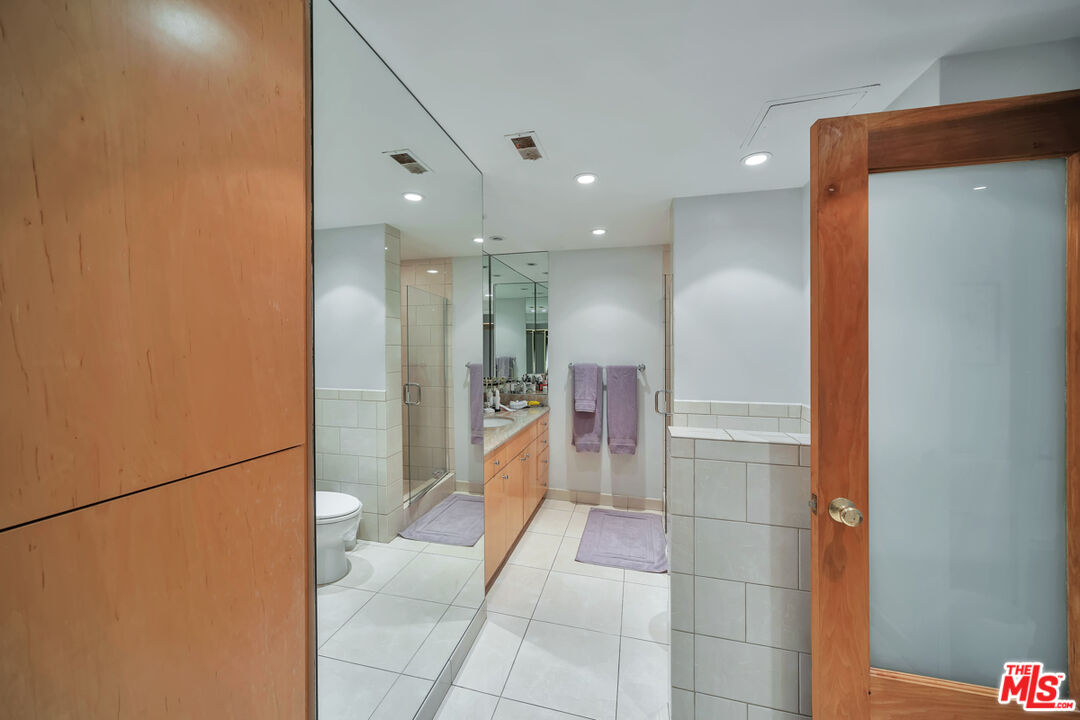 2170 Century Park East, Unit 1807 Los Angeles, CA 90067 - Photo 7 of 30 a bathroom with a glass shower door and a mirror