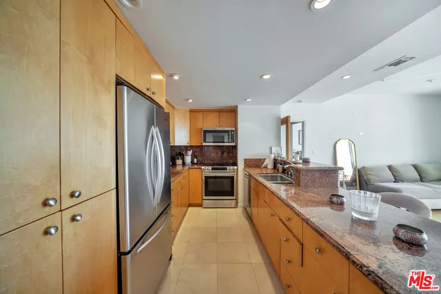 a large kitchen with stainless steel appliances granite countertop a sink and cabinets