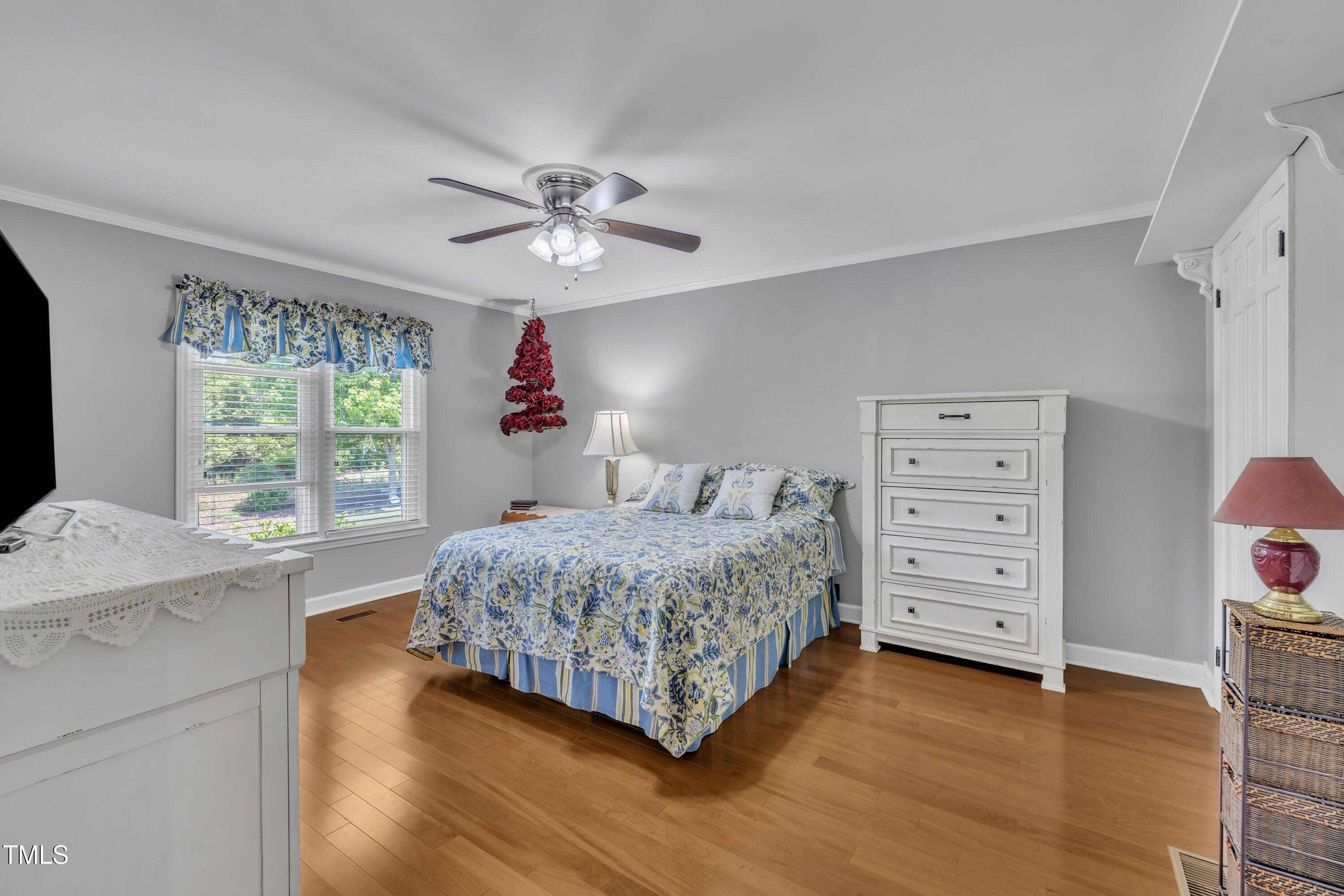 1112 Turner Farms Road Garner, NC 27529 - Photo 23 of 43 a bedroom with a bed chandelier and a window