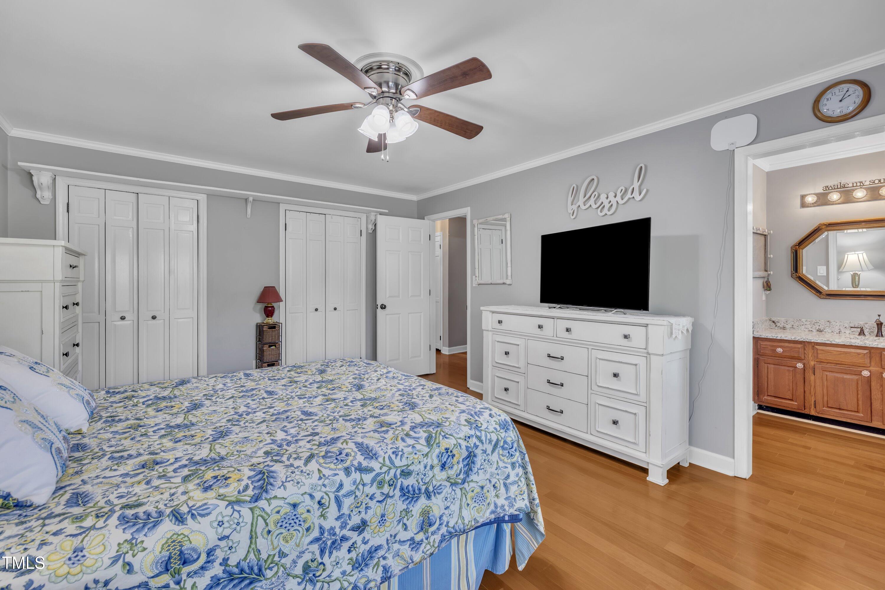 1112 Turner Farms Road Garner, NC 27529 - Photo 25 of 43 a bedroom with a large bed and flat tv screen on dresser