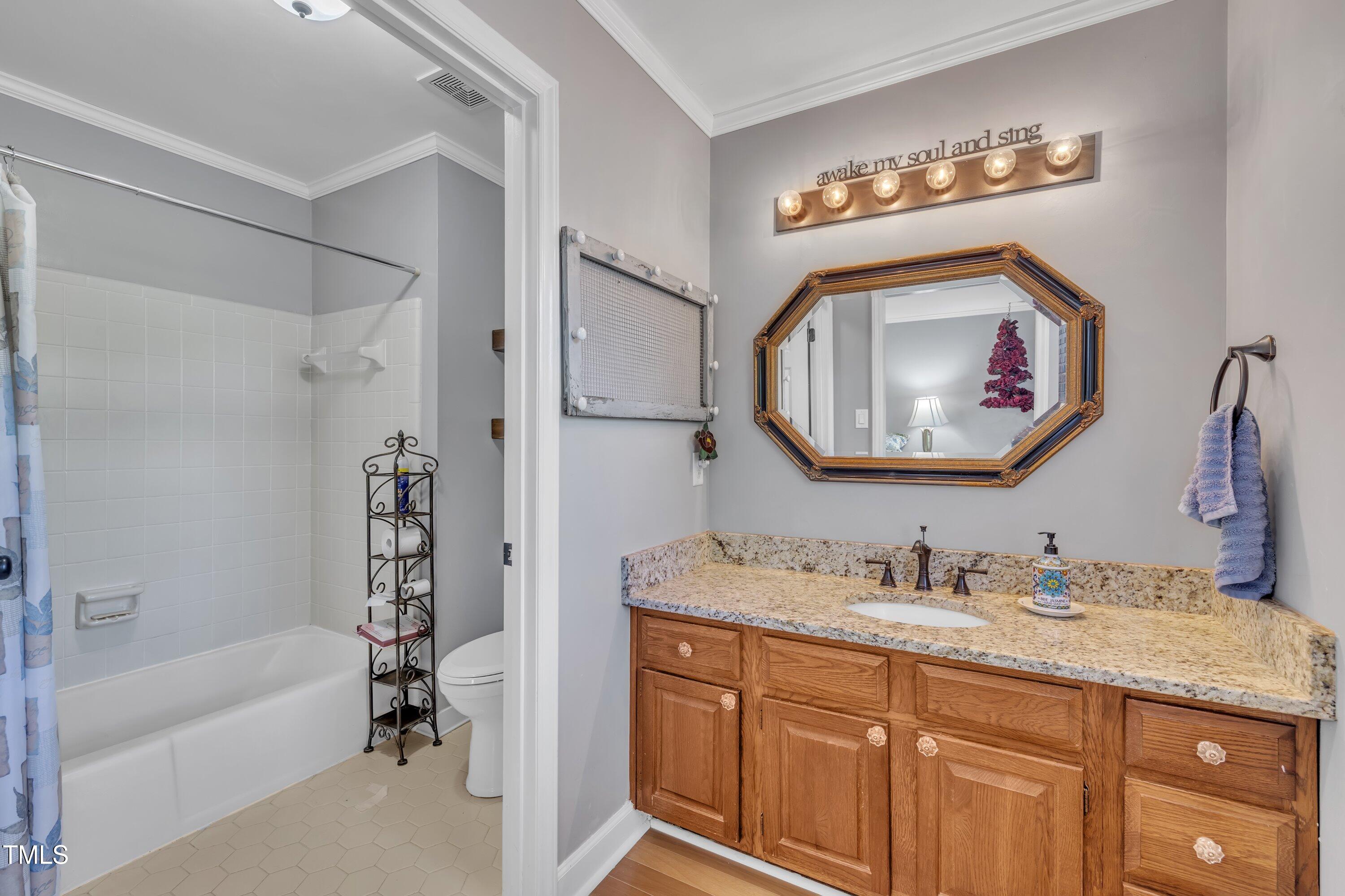 1112 Turner Farms Road Garner, NC 27529 - Photo 28 of 43 a bathroom with a granite countertop tub a sink and a mirror