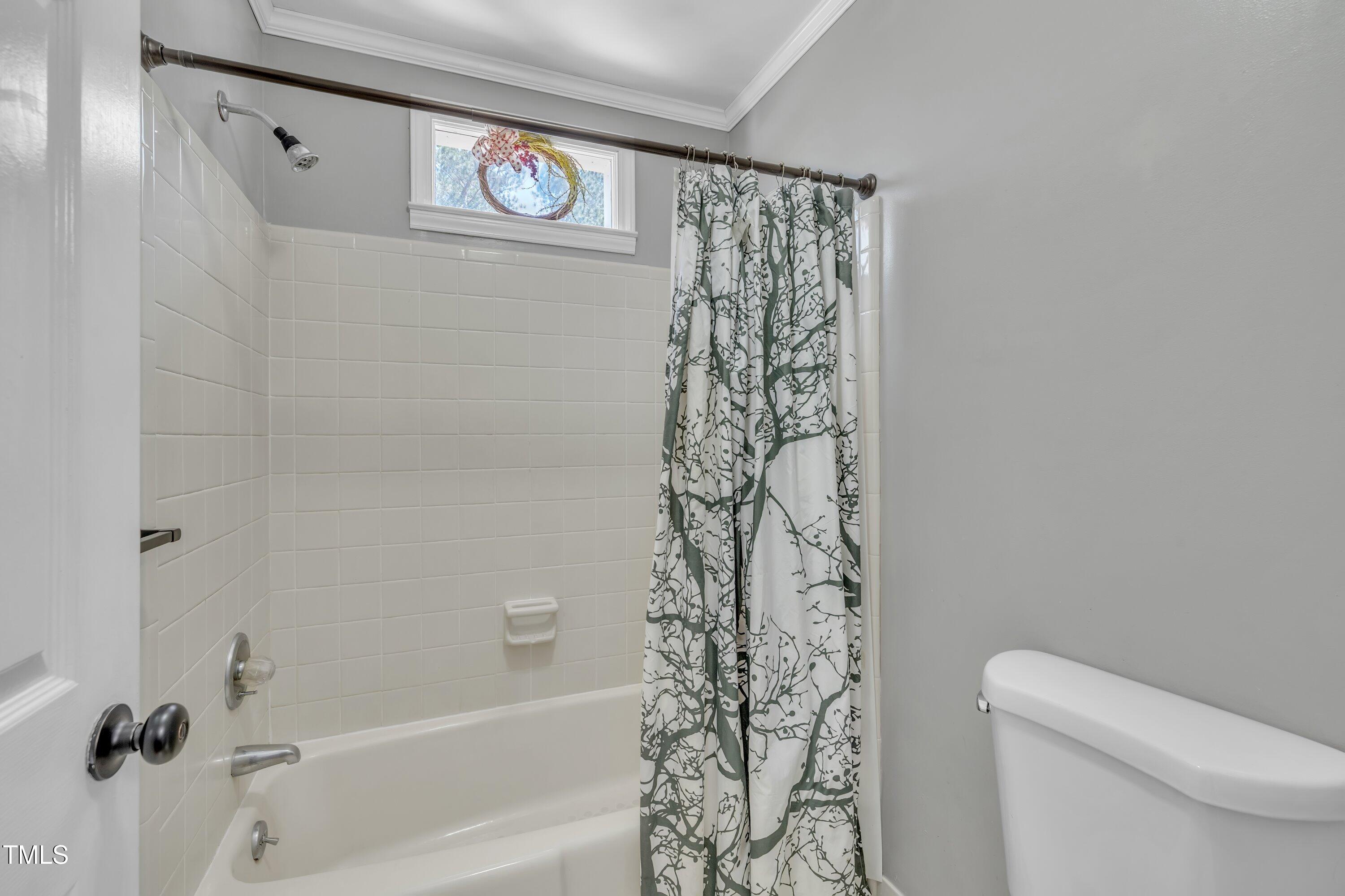 1112 Turner Farms Road Garner, NC 27529 - Photo 35 of 43 a bathroom with a shower curtain and a toilet