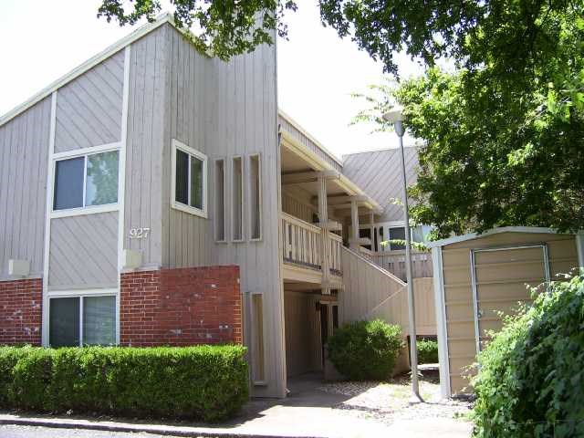 a front view of a house with plants and trees