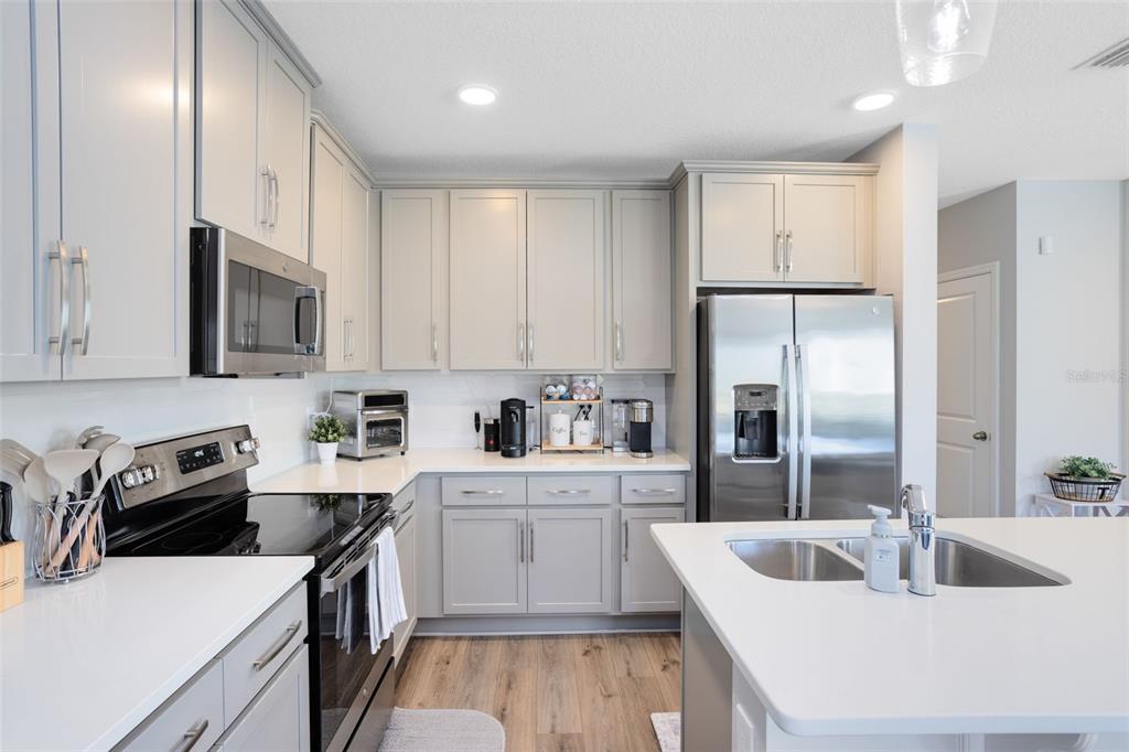 4394 Campsite Loop Orlando, FL 32824 - Photo 11 of 40 a kitchen with white cabinets and stainless steel appliances