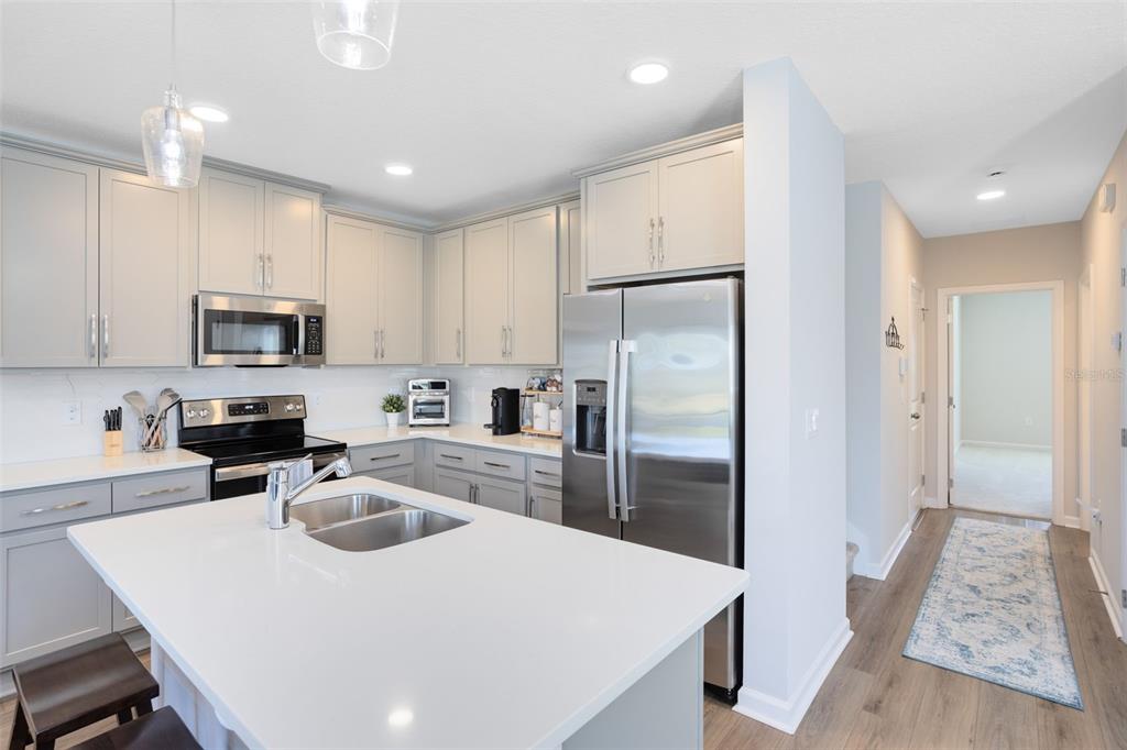 4394 Campsite Loop Orlando, FL 32824 - Photo 13 of 40 a kitchen with white cabinets and stainless steel appliances