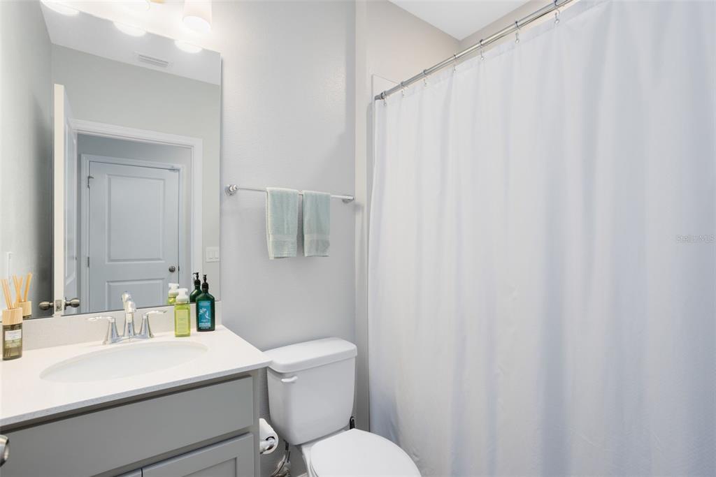 4394 Campsite Loop Orlando, FL 32824 - Photo 16 of 40 a bathroom with a sink a toilet a mirror and shower curtain