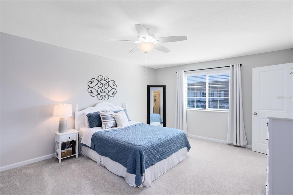 4394 Campsite Loop Orlando, FL 32824 - Photo 19 of 40 a bedroom with a large bed and a chandelier