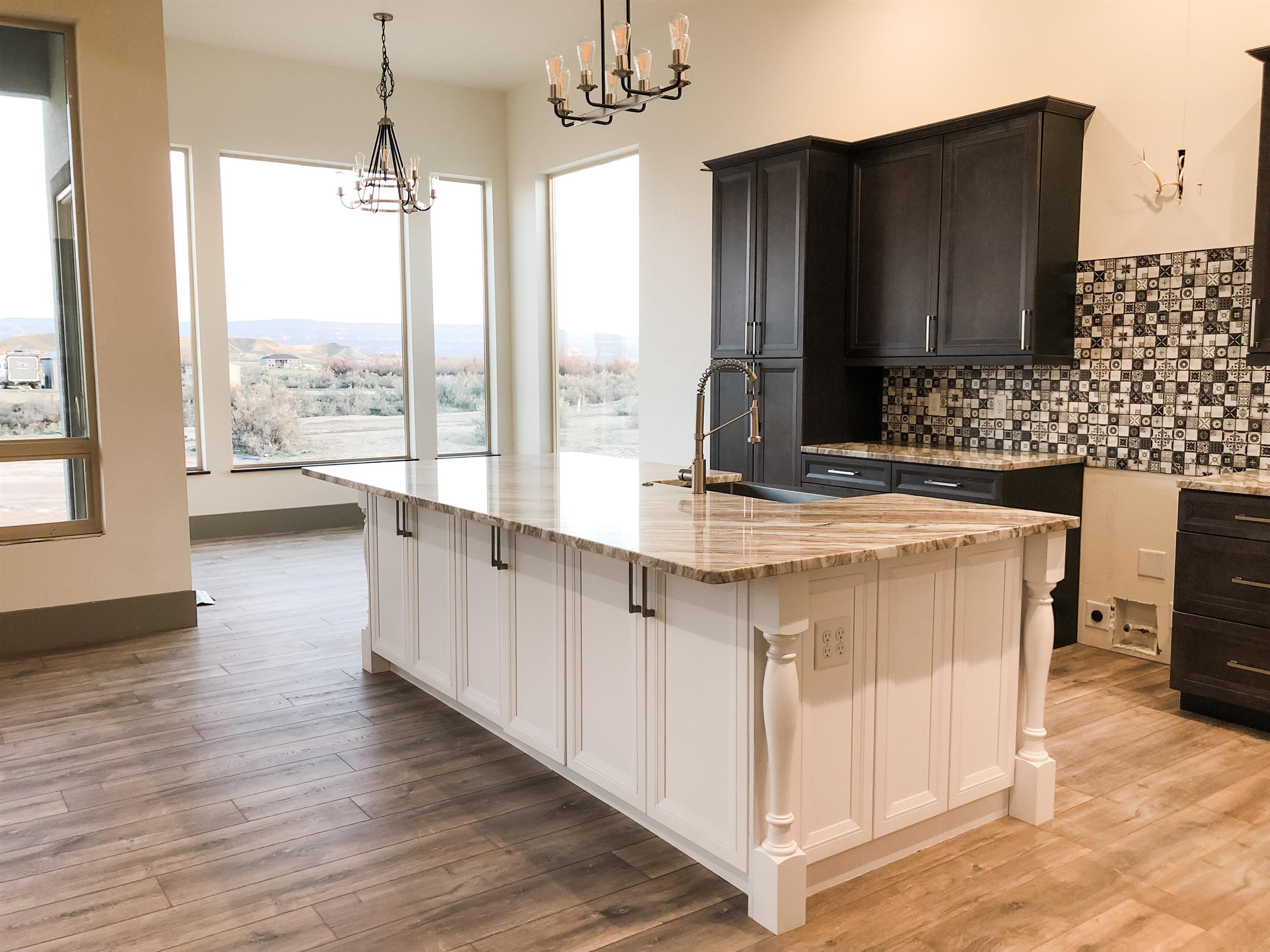 1697 P Road Loma, CO 81524 - Photo 4 of 39 a view of kitchen with kitchen island granite countertop a sink appliances cabinets and a large window