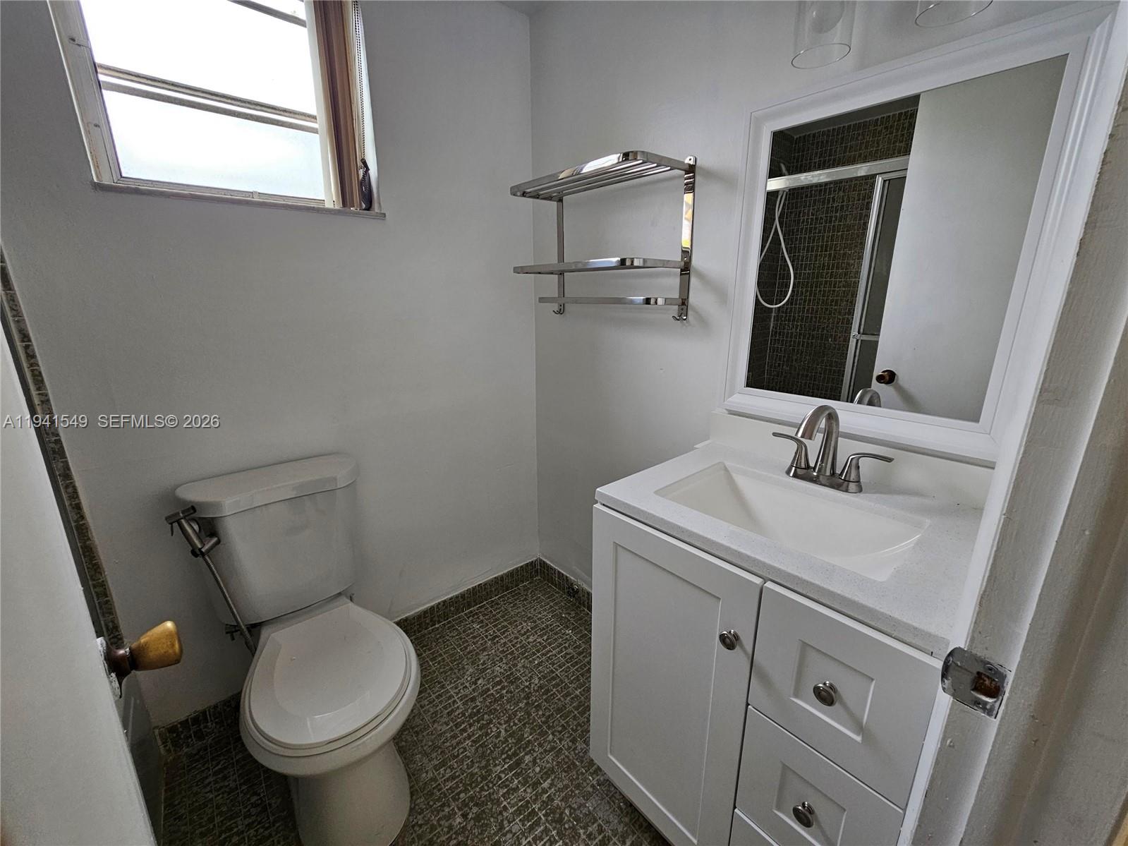 8990 Southwest 24th Street, Unit 228 Miami, FL 33165 - Photo 13 of 20 a bathroom with a sink toilet and mirror