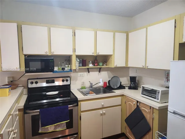 a kitchen with a stove a sink and a microwave