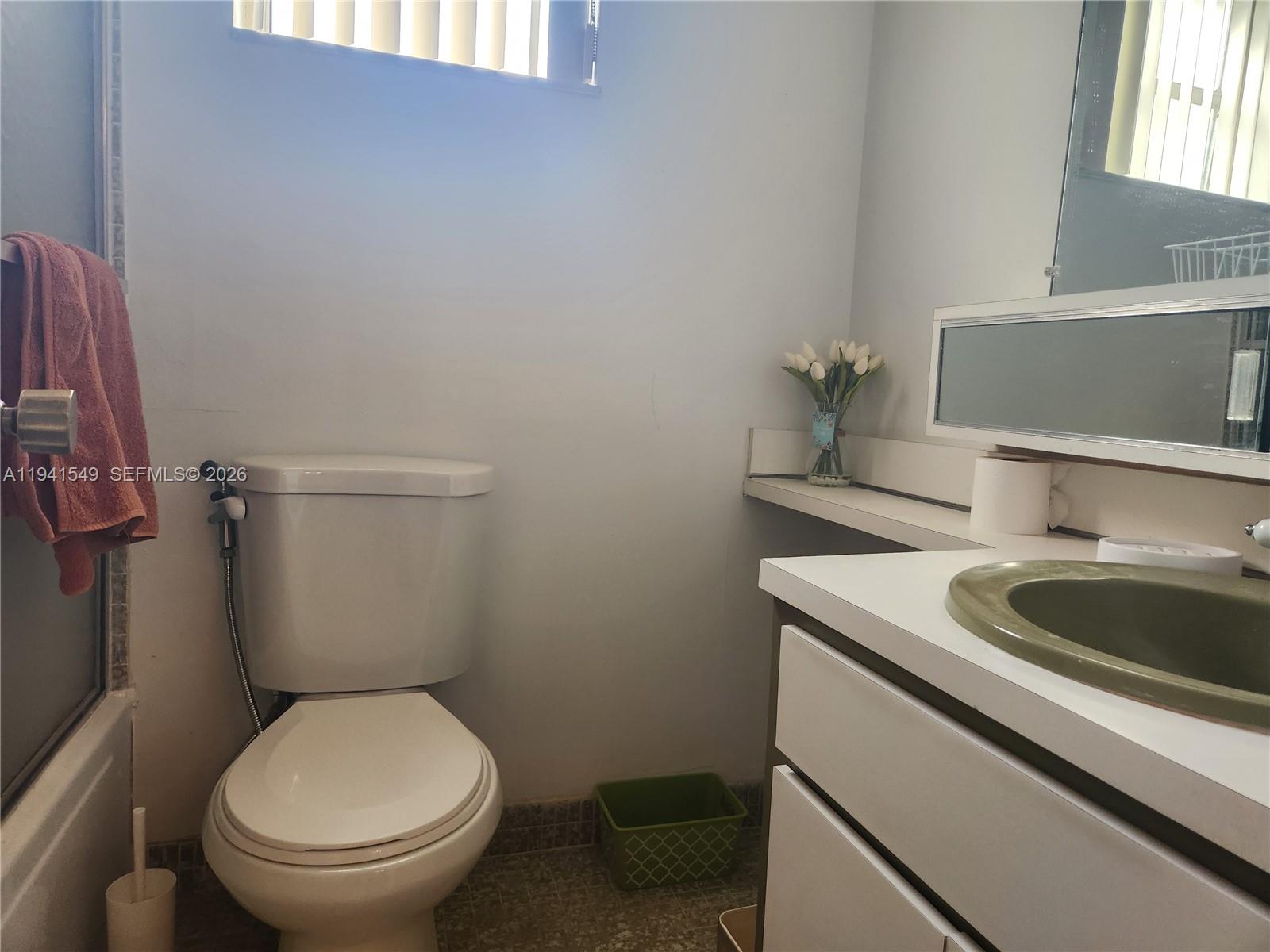 8990 Southwest 24th Street, Unit 228 Miami, FL 33165 - Photo 8 of 17 a bathroom with a toilet sink and mirror