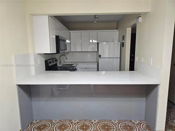a kitchen with a refrigerator and a sink