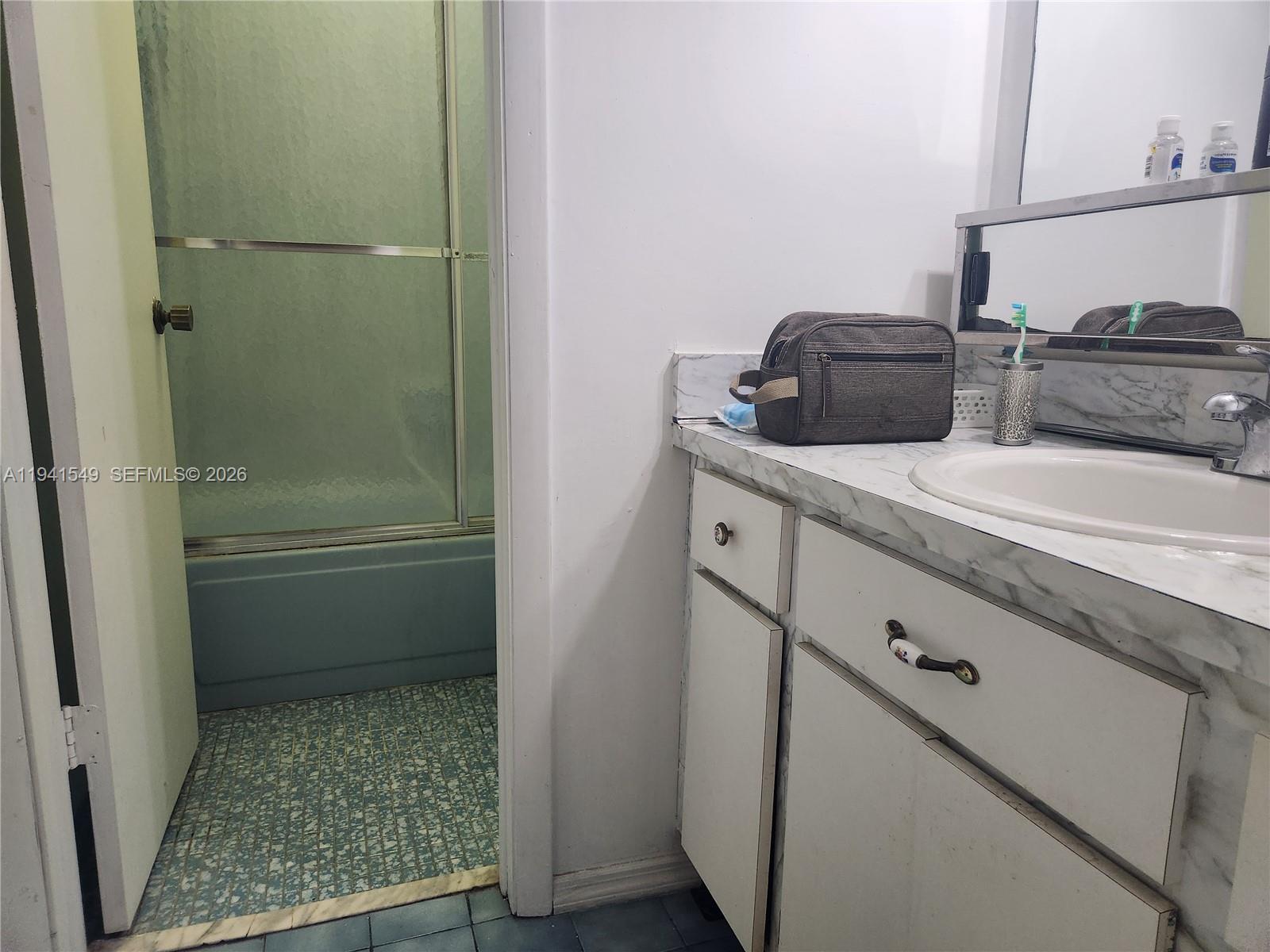 8990 Southwest 24th Street, Unit 228 Miami, FL 33165 - Photo 10 of 17 a bathroom with a granite countertop sink and a mirror