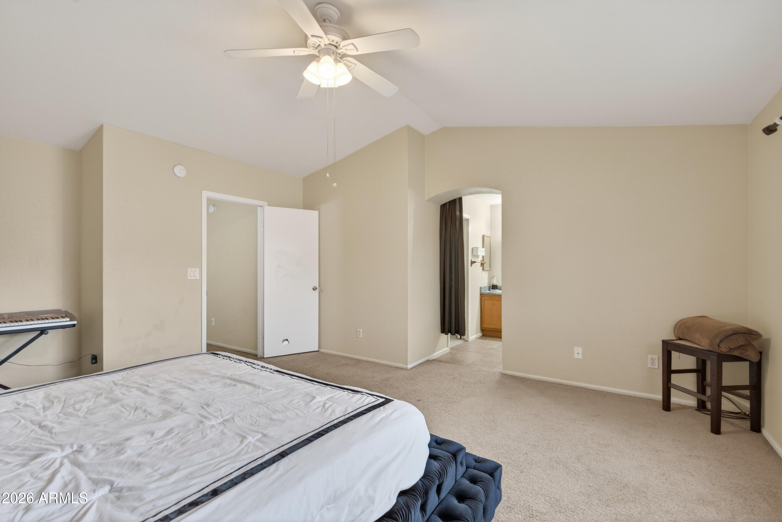4547 North 87th Avenue Phoenix, AZ 85037 - Photo 12 of 22 a bedroom with a bed and a chandelier