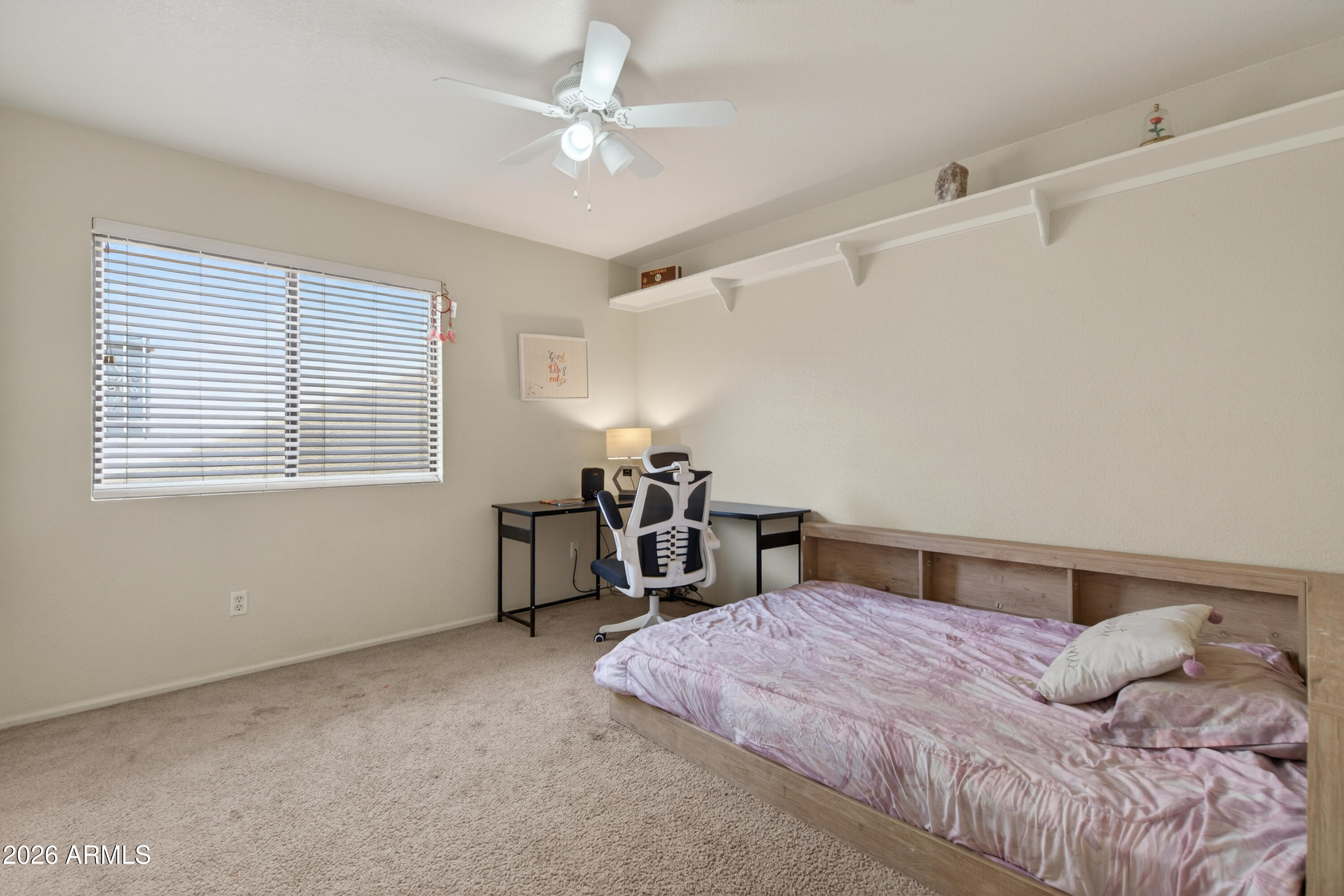 4547 North 87th Avenue Phoenix, AZ 85037 - Photo 15 of 22 a bedroom with a bed and a chandelier