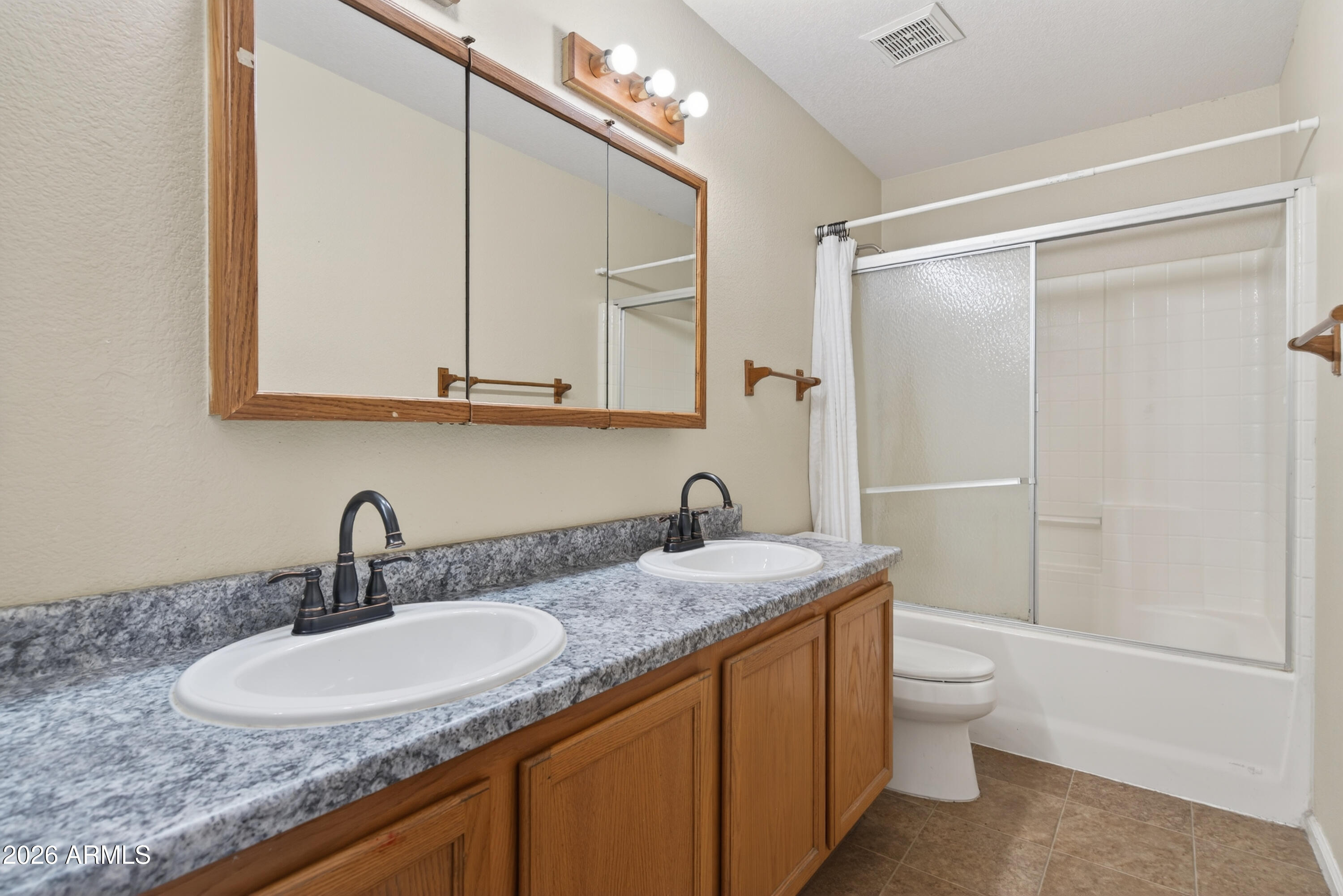 4547 North 87th Avenue Phoenix, AZ 85037 - Photo 17 of 22 a bathroom with a granite countertop sink a toilet and shower