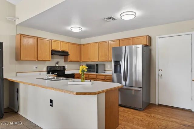 a kitchen with stainless steel appliances granite countertop a refrigerator a sink a stove a microwave and island