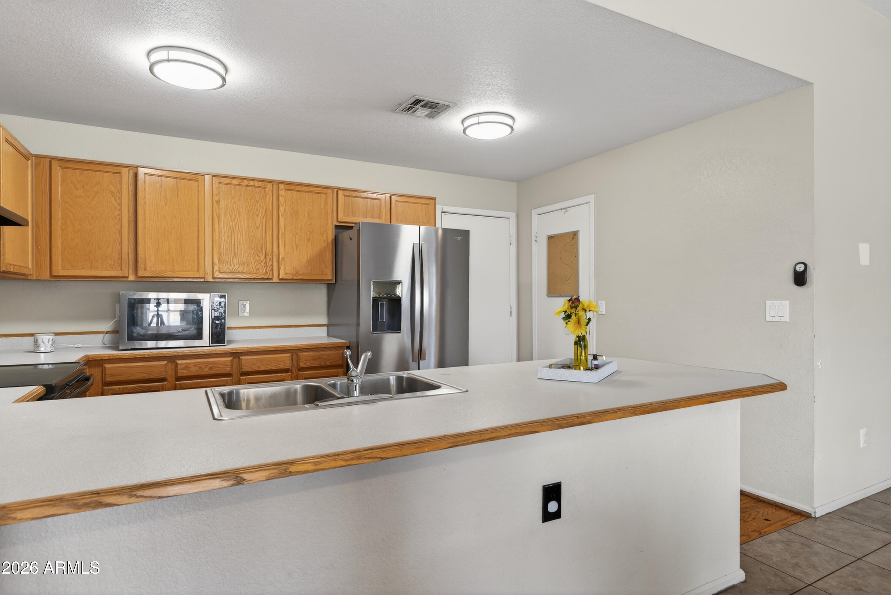 4547 North 87th Avenue Phoenix, AZ 85037 - Photo 7 of 22 a kitchen with stainless steel appliances granite countertop a sink and a refrigerator