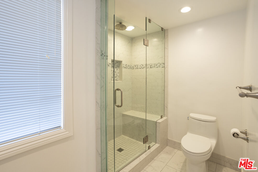 18436 Wakecrest Drive Malibu, CA 90265 - Photo 30 of 41 a bathroom with a glass shower door and a toilet