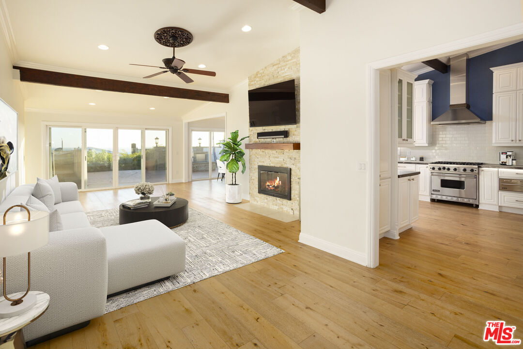 18436 Wakecrest Drive Malibu, CA 90265 - Photo 7 of 41 a living room with furniture a flat screen tv and a fireplace