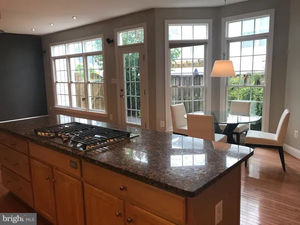 a kitchen with granite countertop a stove a table and chairs in it