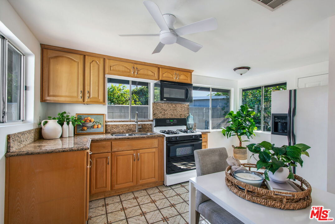 2142 West 11th Street Santa Ana, CA 92703 - Photo 33 of 54 a kitchen with stainless steel appliances a sink a stove a window cabinets and a dining table